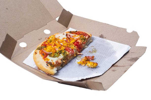 Leftover vegetarian paneer pizza beautifully decorated in a cardboard box on white background.