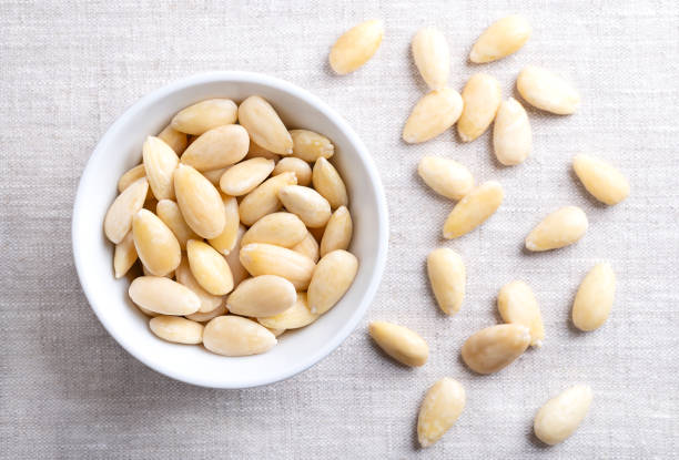 istock Freshly blanched almonds in a white bowl on linen 2179741461