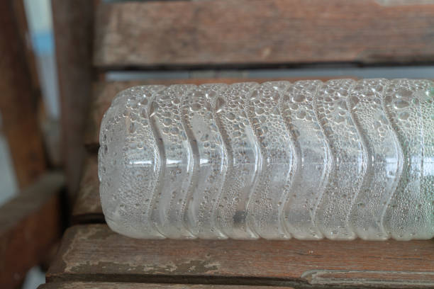 Water droplets in a plastic bottle placed on a wooden bench