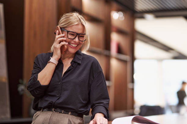 istock Professional Woman Engaged in a Phone Conversation in a Modern Workspace Setting and Environment 2179745931