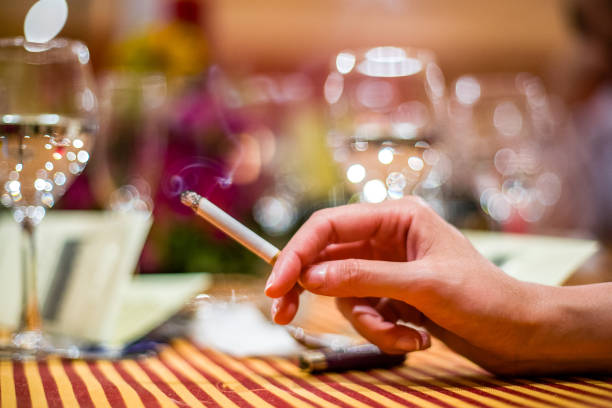 istock Elegant Woman Holding Cigarette at Restaurant Table 2179746228