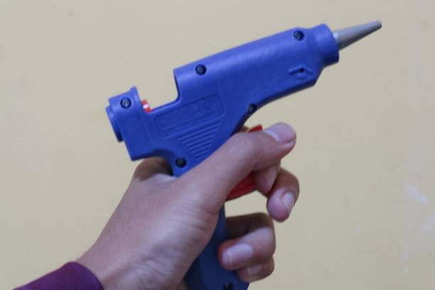 istock A hand is holding a blue hot glue gun 2179746938