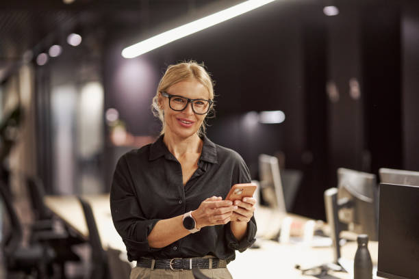 istock A Professional Woman Utilizing a Smartphone While Situated in a Contemporary Office Space 2179747717