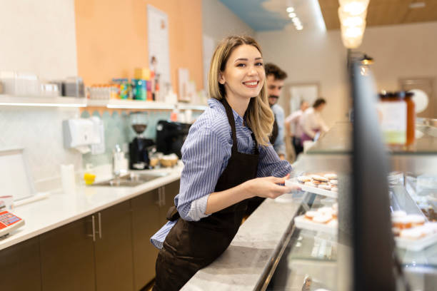 istock Smiling young baker at the checkout counter. 2179753560