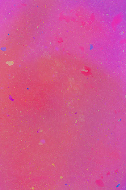 This image features a vibrant pink background with speckles of various colors scattered throughout, creating a glittery effect. The speckles range in color from blue and yellow to white and red, giving the impression of a colorful, starry nebula or a paint-splattered canvas. This background is perfect for adding a festive and lively touch to any creative project.