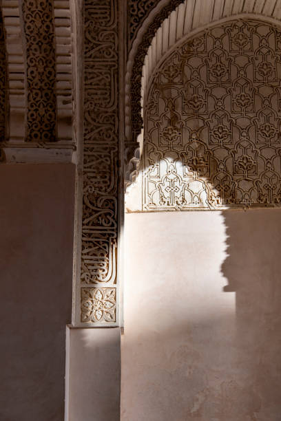 Granada, Spain-February 7, 2024; Interior view of walls and arches with decorations in The Alhambra palace, with Islamic architecture and Spanish Renaissance architecture; shadow on wall