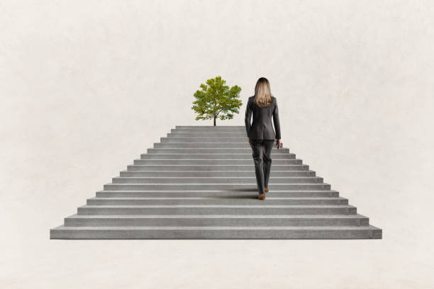 istock Woman Climbs Steps Toward Tree At The Top 2179767526