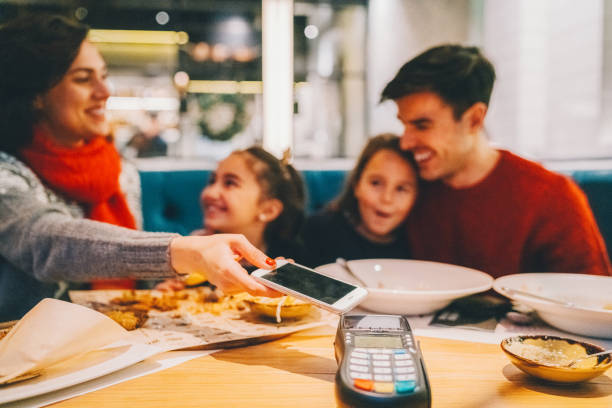 istock Family in restaurant paying contactless 2179770220