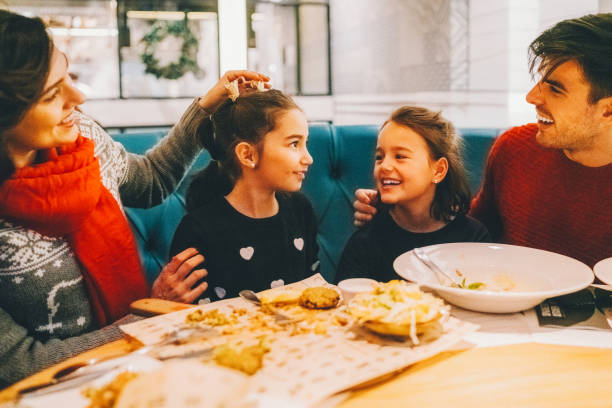 istock Family with two kids eating dinner in restaurant 2179770273