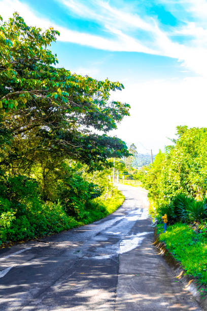 Village road and path through natural land and forest with mountains in Para Heredia Costa Rica in Central America.