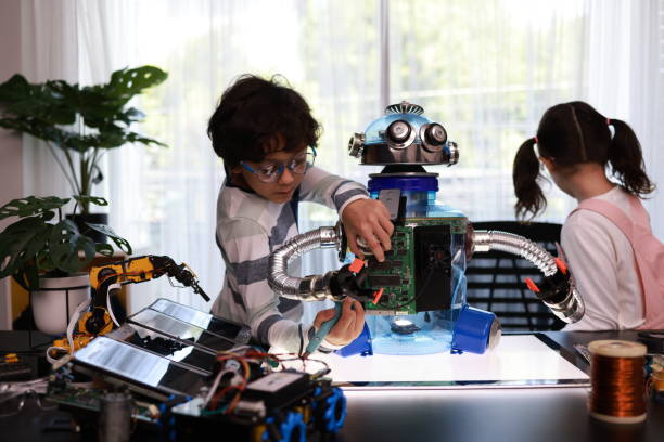 istock A Cheerful school boy and a school girl look in concentration while assembling a robot in a technology classroom. Improve kid's learning skills and motivation concepts. 2179774567