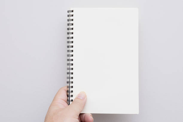 istock Hand holding an empty notebook or book. Mockup book. Blank notebook, blank book. free space on book for adding texts. 2179779306