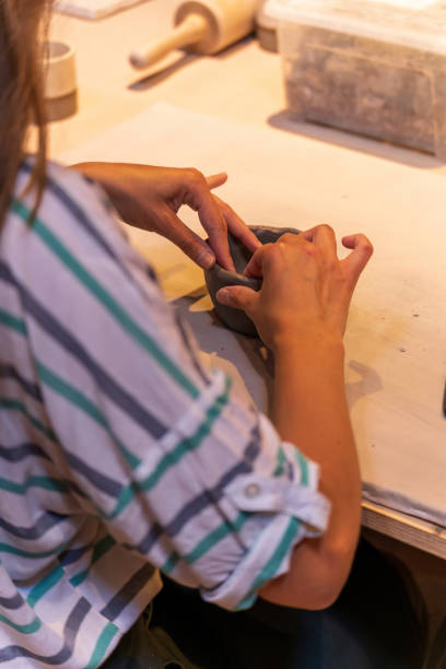 istock A potter's hands shaping a clay bowl on a pottery wheel. 2179793068