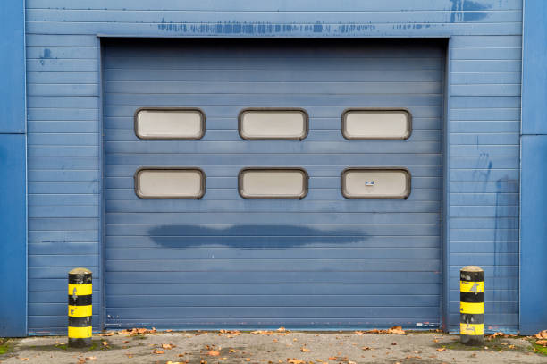 Blue industrial garage door with six windows is showing its age with weathered paint and rust