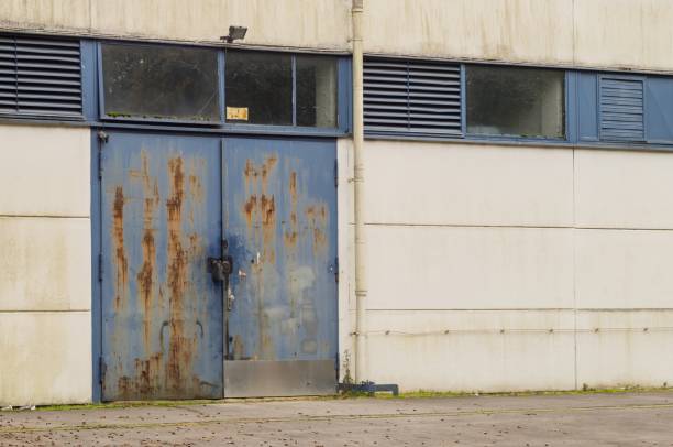 istock Old rusty blue industrial door with padlock showing decay and decline 2179793678