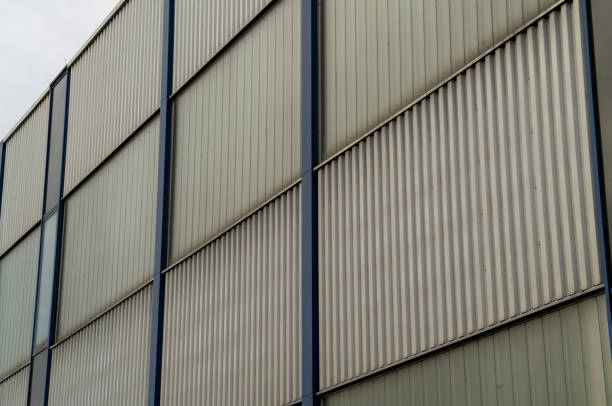 Modern building facade showing metal panels and glass windows forming a repetitive pattern