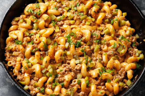 istock Cheeseburger Pasta with ground beef, melted cheese and gherkins in a iron cast pan 2179803966