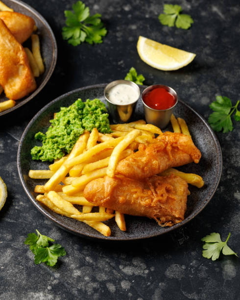 istock British Fish and chips with mashed peas, tartar and ketchup sauce. 2179804002
