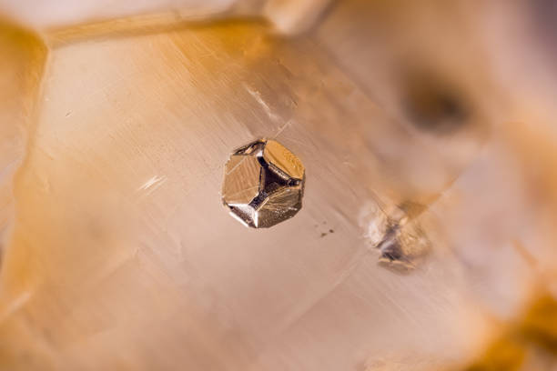 Octahedron Pyrite inclusion in orange Calcite. Specimen from La Sambre quarry, Landelies, Belgium. Micro photography extreme close-up. microscope mineral crystal photography for Scientific use.