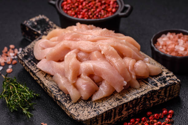 istock Raw chicken fillet cut into strips with spices and herbs 2179811656
