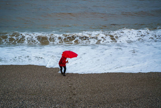 Lonely man walking on the beach on a rainy day Konyaalti Beach, Antalya