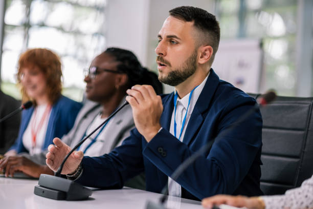 istock Man CEO talking on the microphone on meeting with his colleagues about business plan, future collaboration. 2179816074