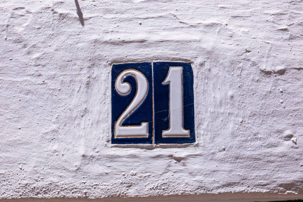 istock Beautiful house number 21 in Spanish style. House number on a ceramic patterned base in the old town in Spain. Traditional Spanish patterned decoration of a plate with an apartment or house number 2179817675