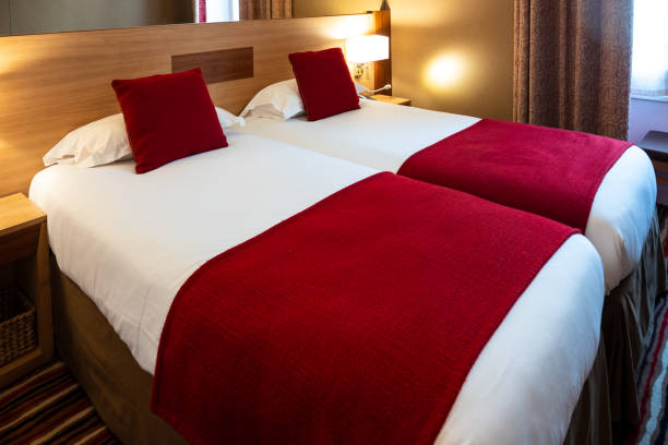 istock twin bed in a hotel room with white and red linen 2179820114