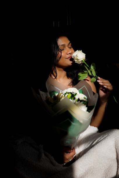 istock Woman with white rose in dim light 2179820173