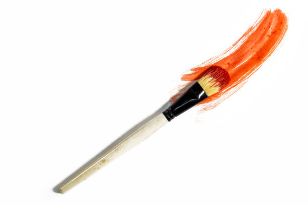 Vibrant red paint stroke on a white background with a brush to paint over it