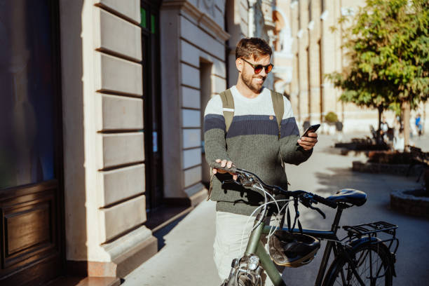 istock A man rides a bicycle through a historic European square surrounded by classical architecture and using smart phone. Man is smiling while looking at mobile phone 2179826396