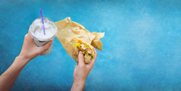 istock Milkshake and hamburger in man’s hands 2179828342