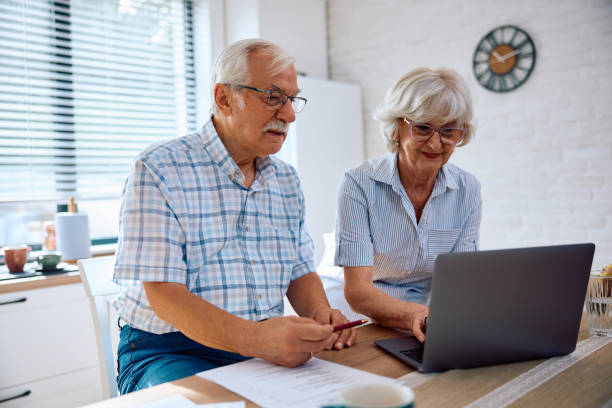 istock Happy senior couple using laptop while going through their savings at home. 2179832016