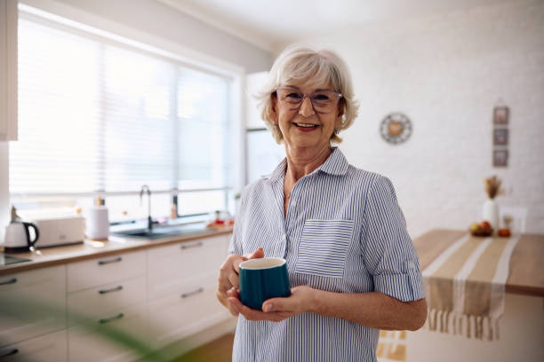 istock Happy senior woman drinking tea in the kitchen and looking at camera. 2179832094