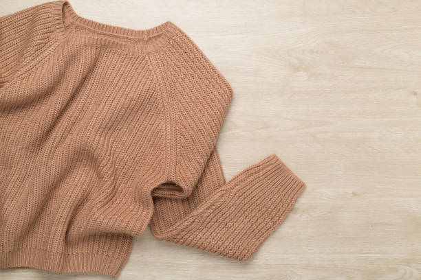 istock Brown sweater on wooden background, top view 2179839242
