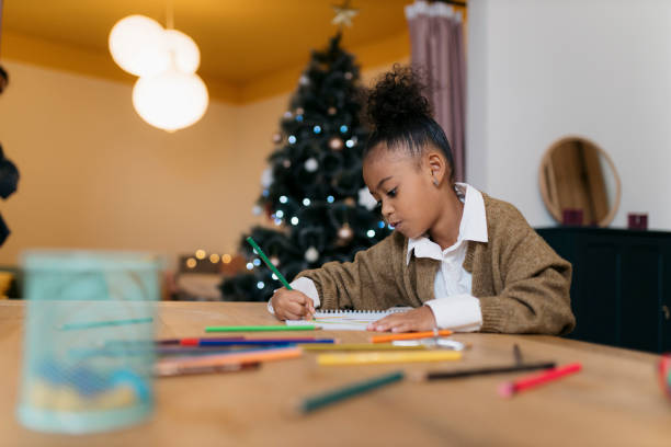 istock Small girl busy doing drawing at home during Christmas 2179845580