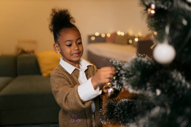 istock Small girl decorating christmas tree with ornaments at home 2179845764