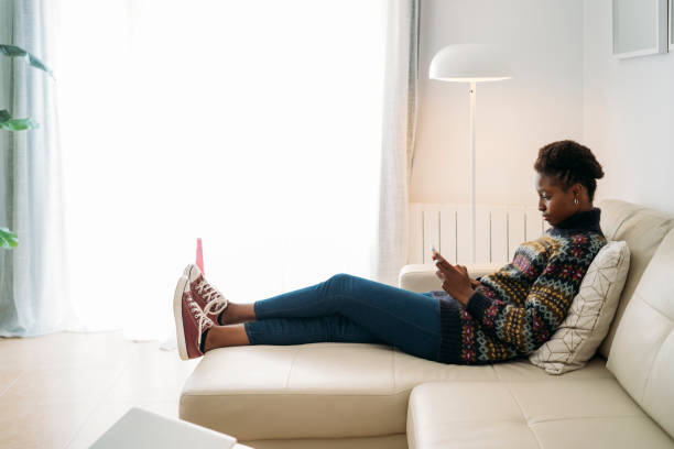istock Savoring a Relaxing Moment on a Comfortable Sofa at Home while Engaging with a Smartphone 2179846360
