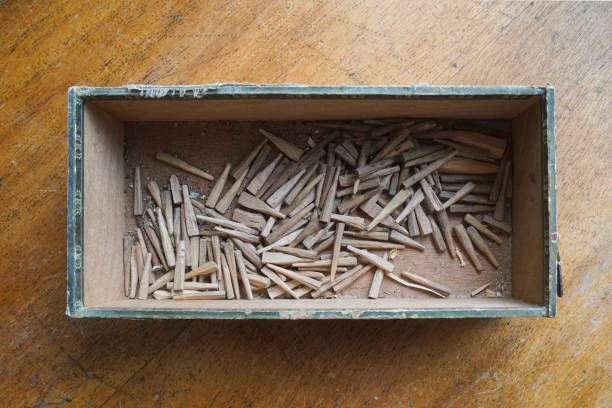 This old box with handmade wooden pins belonged to a chair maker, the pins have been used for keeping the wicker cane in place while weaving the seat of the chair with Viennese braid or wickerwork. View directly from above.