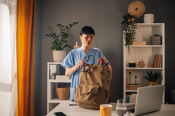 istock Asian woman nurse packing stethoscope into brown backpack in a modern workspace 2179848966