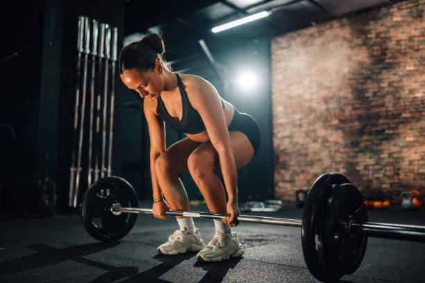istock Young fit woman lifting heavy barbell during cross training workout 2179850122