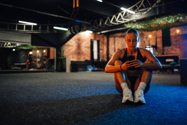 istock Young athletic woman using smartphone after training session in gym 2179850132