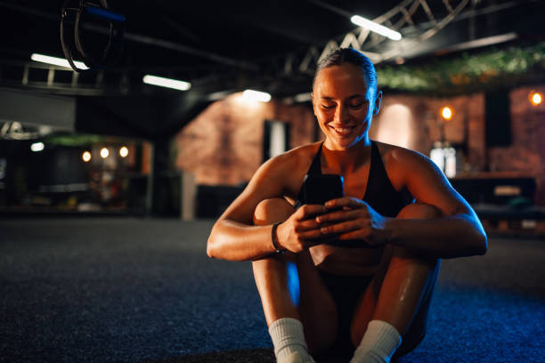 istock Smiling sportswoman using smartphone at the gym after training session 2179850146
