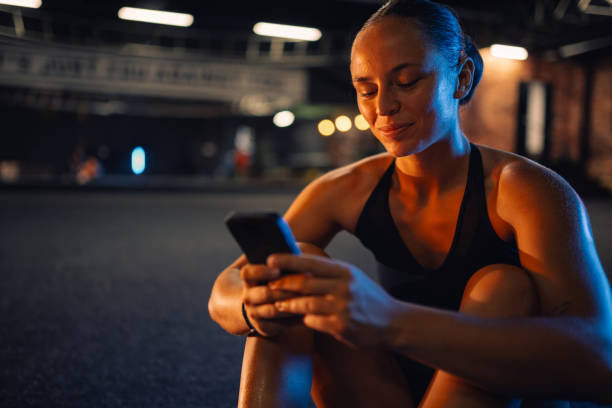 istock Young athletic woman using smartphone after training session in gym 2179850183