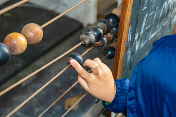 istock Child hand counting on ancient retro old abacus, moving beads, close-up 2179853945