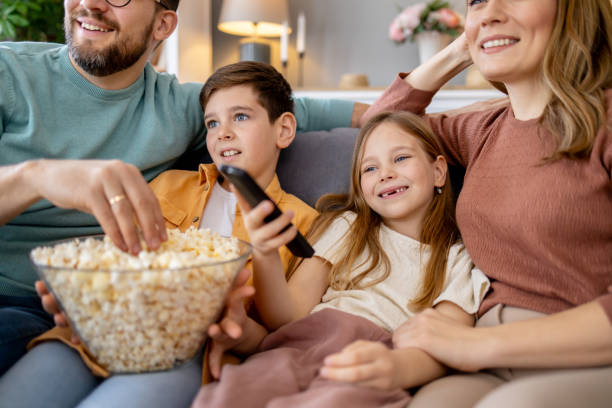 istock Happy family sharing popcorn on couch 2179859238