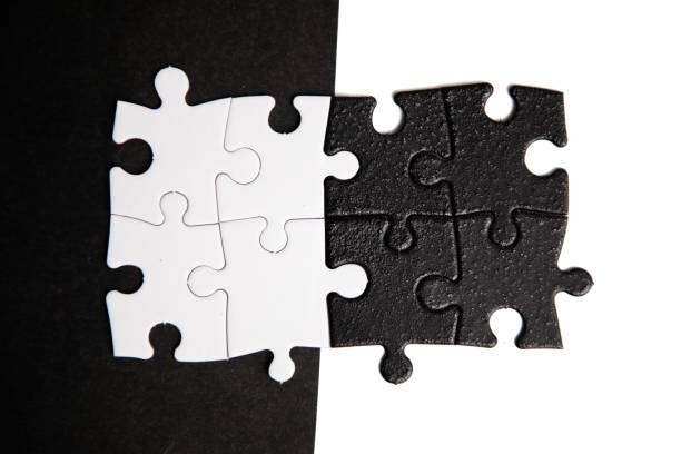 istock Opposite day concept using white and black puzzle pieces with oposite background color. 2179862555