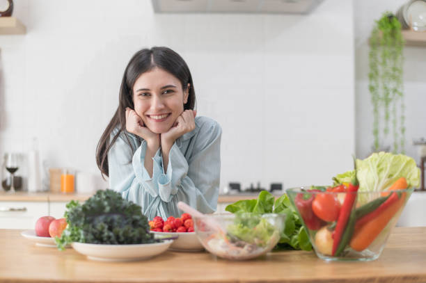 istock Happy young beautiful woman posing with various Fresh Vegetable Salad on counter in kitchen 2179864162