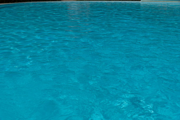 Small tiles in the background, clean light water waving and reflections in swimming pool full frame view suitable for  background purposes. Vigo city, Pontevedra province, Galicia, Spain.