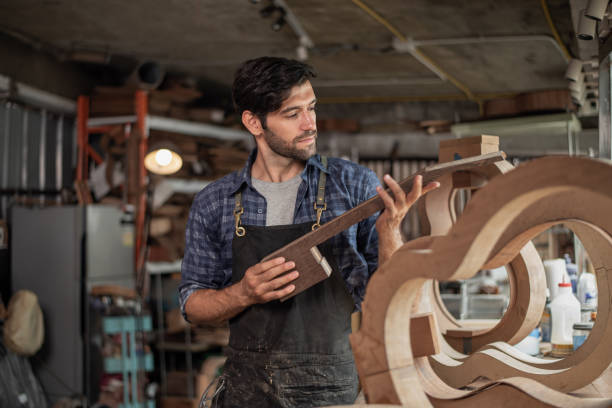 istock Luthier is working on the neck of a classical guitar 2179864253